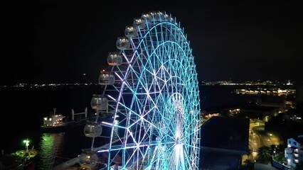 Rio de Janeiro, Brazil - August 3, 2022: Aerial view of Yup Star (Rio Star) ferris wheel at night is illuminated with colorful RGB led lights.