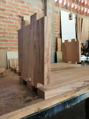 wood piece with dovetail attachment. Dovetail joint on working table. Chisel and wood chips.