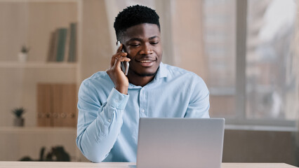 African american man businessman freelancer worker talk chatter on mobile cellphone with client...