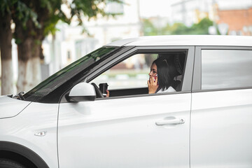 Fototapeta na wymiar young beautiful brunette woman driver sitting in her car with a glass of coffee and talking on the phone