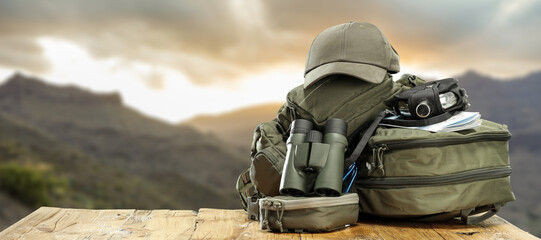 Backpack on table and landscape of mountains. 