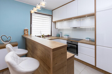 Fototapeta na wymiar Modern white kitchen interior with wooden worktops