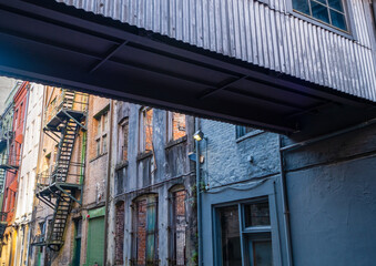 Alley with fire escapes and crossover walkway in downtown New Orleans, Louisiana, USA