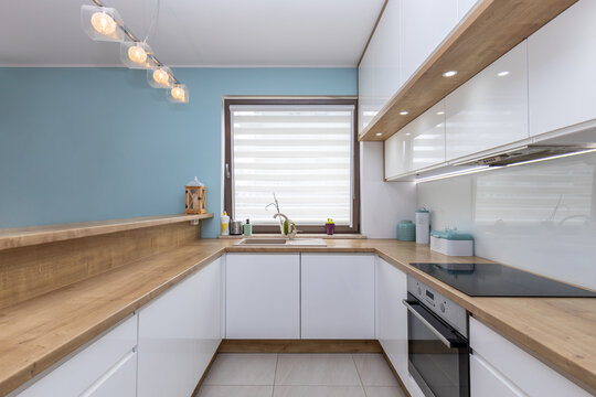 Modern white kitchen interior with wooden worktops