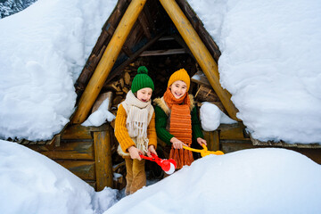 Two small smiling children have fun making snowballs with toy plastic maker. Children are dressed...