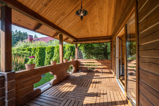 interior of empty hall veranda in wooden village vacation home with garden chairs