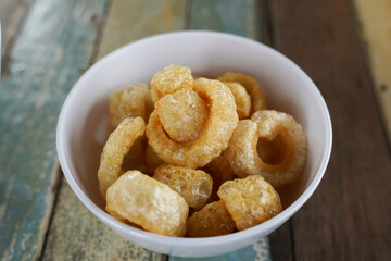 Pork biscuits made from crispy pork skin in a white bowl.