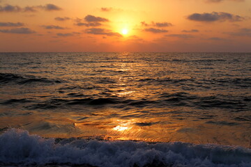 Obraz premium The sun sets below the horizon on the Mediterranean Sea in northern Israel.