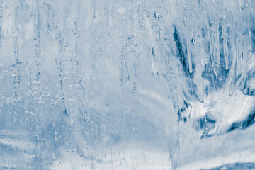 Block of pure transparent ice in cold blue tones. Ice structure.