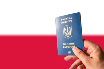 Biometric passport of a citizen of Ukraine in a woman's hand against the background of the national flag of Poland. Escape from Russian aggression of Ukrainians to Poland, emigration.