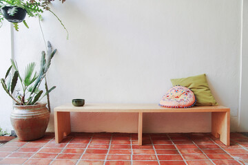 wooden bench, with cactus, cushions and plants.
