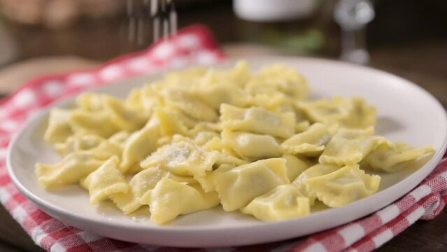 Plin del Piemonte. ravioli del plin typical Piedmontese filled pasta from the Langhe in Italy seasoned. Hot steam coming from the plate. High quality FullHD footage