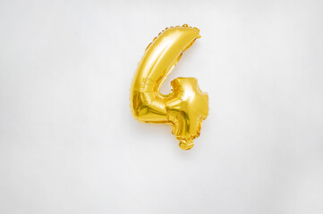 number four celebration metallic gold color helium balloon on an isolated white background