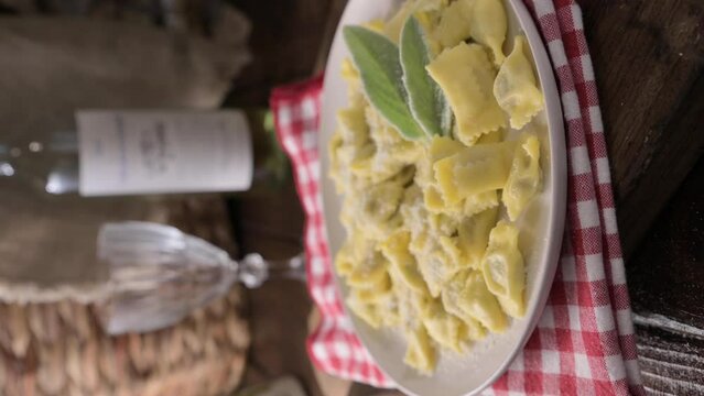Plin del Piemonte. ravioli del plin typical Piedmontese filled pasta from the Langhe in Italy seasoned. Hot steam coming from the plate. High quality FullHD footage. Vertical Video