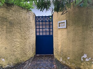 Portão azul e muro amarelo