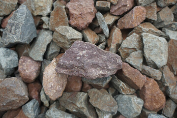 A sample of rhyolite rock shows a pinkish color, abundant white phenocrysts of K-feldspar, and some...