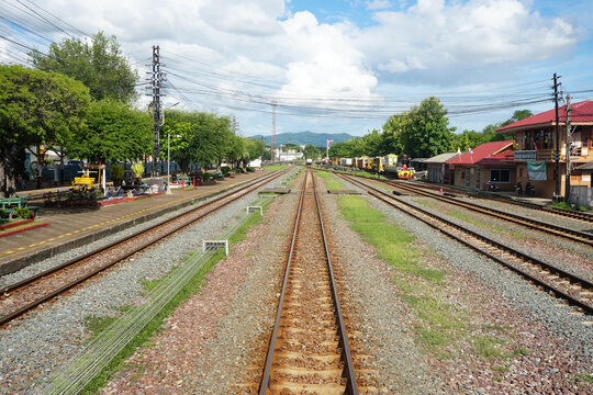 Railway tracks at a Thai train station on a clear day.