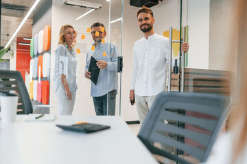Obraz premium Three people standing together. Group of professional business people is in the office