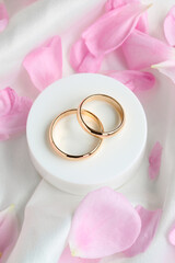 Two wedding gold rings and rose petals.