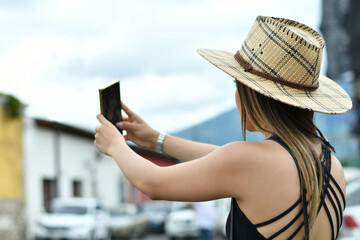 Fototapeta premium Mujer Guatemalteca tomando una fotografia mientras esta de viaje por Antigua Guatemala. 