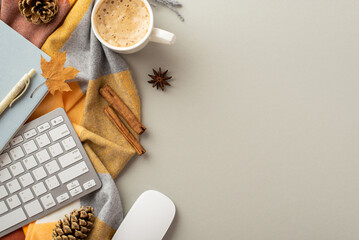 Autumn business concept. Top view photo of workplace computer mouse keyboard notepad pen cup of hot drinking yellow maple leaf anise pine cones cinnamon sticks and plaid on isolated grey background