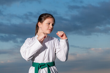 judo girl in kimono on sky background