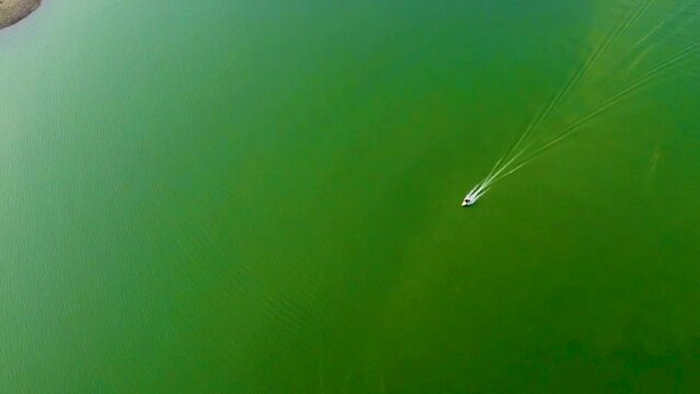 isolated speed boat running on lake water from top angle