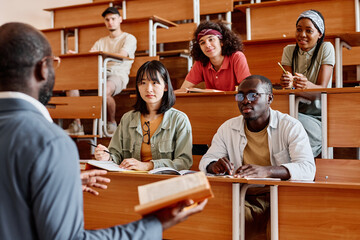 Group of students listening to teacher during lecture at university