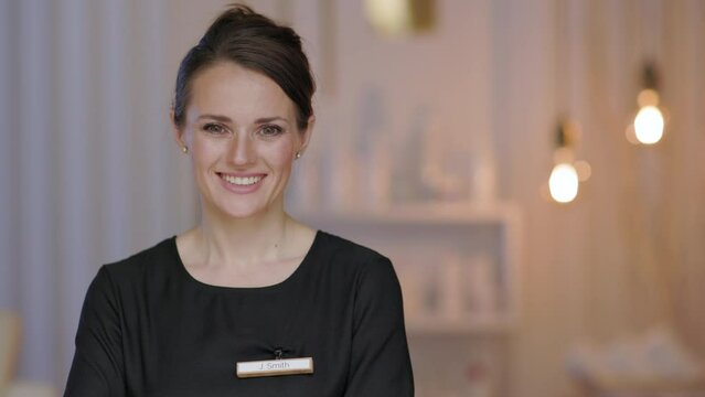 smiling 40 years old woman worker in modern beauty salon.
