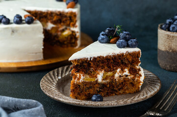 piece of carrot cake with walnuts and blueberry on dark wood background. Local food. Traditional american cake. Cake for thanksgiving day. Christmas cake.