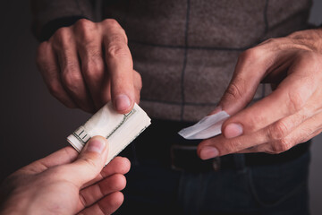 closeup of a drug addict with money buying a dose