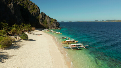 aerial view island with tropical sandy beach and palm trees. Malajon Island, Philippines, Palawan. tourist boats on coast tropical island. Summer and travel vacation concept. beach and blue clear sea