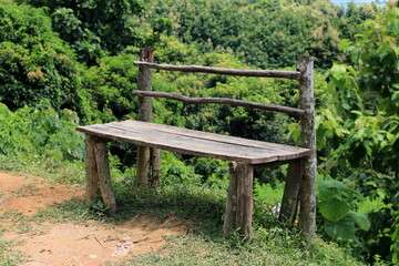 Fototapeta na wymiar Wooden Bench on the hill road side with mountain and forest at Rangamati, Bangaldesh. It is mainly used for people relaxing, panoramic top view observe.