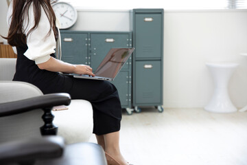 A Japanese woman typing laptop by remote work in the office faceless composition
