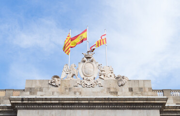 Flags of Catalonia, Spain and Barcelona flying over Barcelona City Hall. Neoclassical façade of the City Hall.