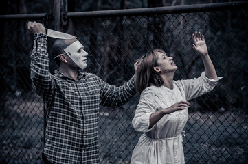 A serial killer scene is about to kill an Asian woman,concept thriller scene,Halloween festival