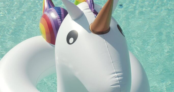 Close-up Inflatable colorful white unicorn at the swimming pool. Fun time in the Summer at swimming pool. High quality 4k footage