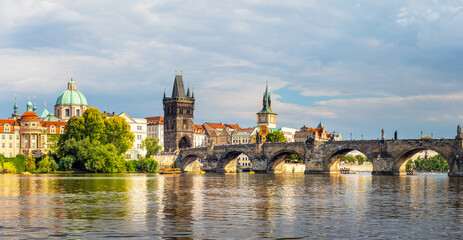 waterfront view across the river Vltava to the Charles Bridge and Old Town Bridge Tower, Prague,...