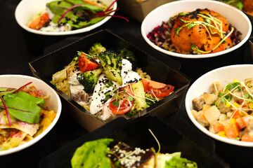 Balanced box diet. Menu suggestions in catering with delivery. Ready healthy food menu in lunch boxes with fish and vegetable packages as daily courier delivery diet plan on black background.