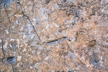 old weathered rock wall with beautiful cracks, pattern and texture, colorful background, textured surface