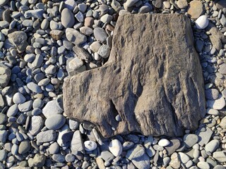 Grey stone on pebbles at the beach in Ireland.