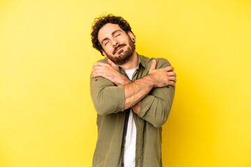 young bearded man feeling in love, smiling, cuddling and hugging self, staying single, being...