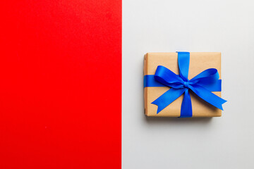holiday handmade paper present tied blue ribbon bow top view with copy space. Flat lay holiday background. Birthday or christmas present. Christmas gift box concept with copy space