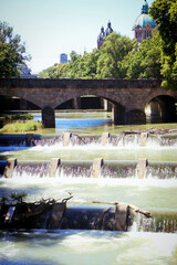 Munich, summer view of Isar river with the rapids from the city promenade