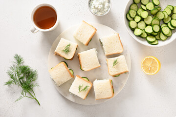 Cucumber sandwiches with ricotta and dill on white background. Top view. Copy space. Traditional English tea appetizer.
