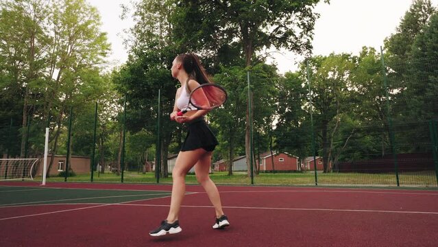 slender female tennis player in court outdoors, athletic woman in short skirt and sporty top