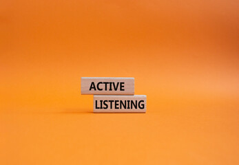 Active listening symbol. Wooden blocks with words Active listening. Beautiful orange background....