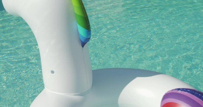 Inflatable colorful white unicorn at the swimming pool.Pool Beach Vacation travel concept with inflatable unicorn float toy mattress by luxury swimming pool. Luxury lifestyle summer holidays travel