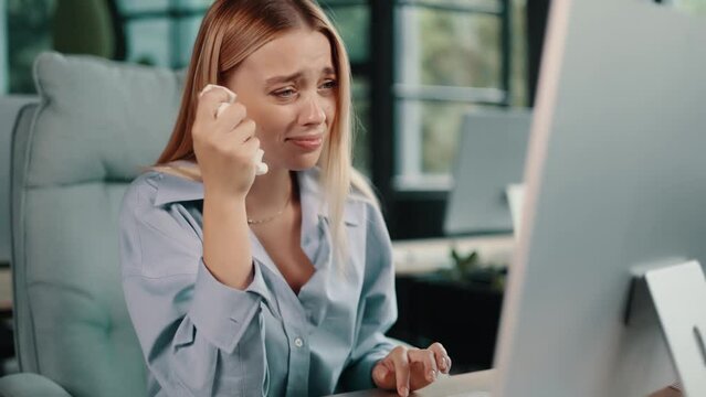 Crying businesswoman feeling unhappy using computer. Sad office worker having problem with her work. 