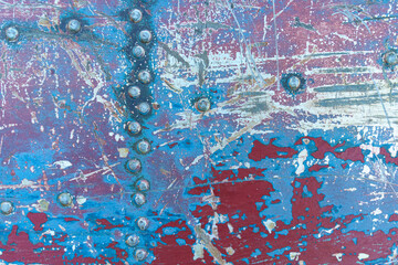 Texture of rusty metal with rivets, blue and red paints.